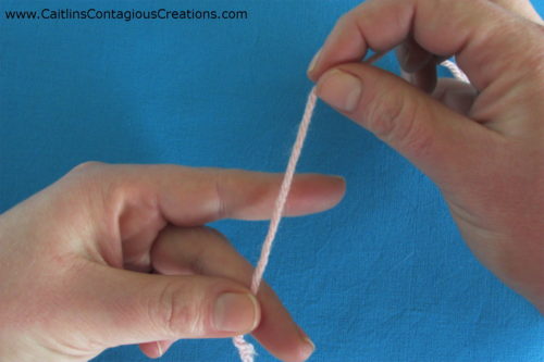 hold yarn end between thumb and middle finger of tension hand