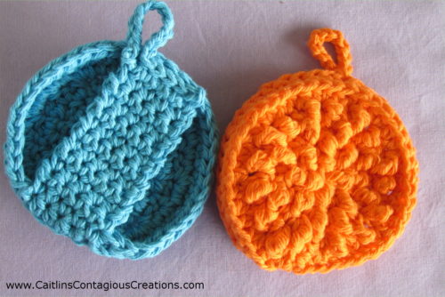 Front of orange scrubby showing texture of pad and back of blue face scrubby showing handle