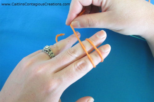 turn yarn hand over to show tops of fingers with two parallel loops of yarn on back