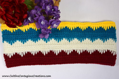 Staged photo of finished cascading icicles cowl with purple and red flowers